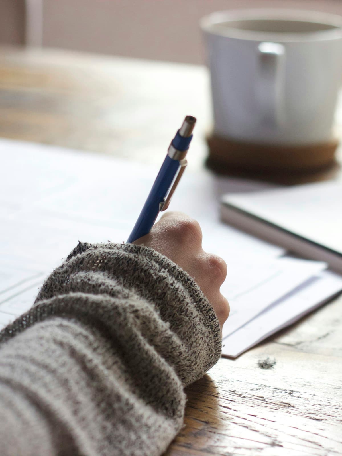 A person taking thoughtful notes at a table
